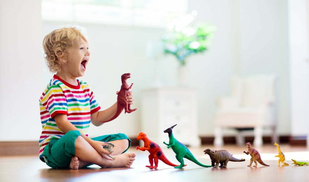 dziecko bawiące się figurkami dinozaurów
