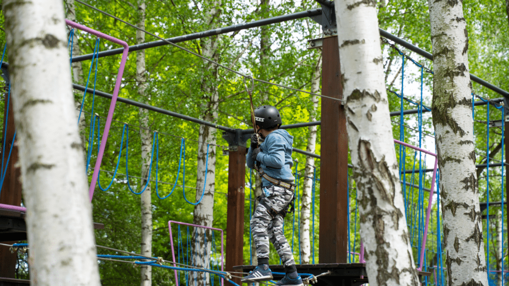 Chłopiec w parku linowym w parku rozrywki Zatorland